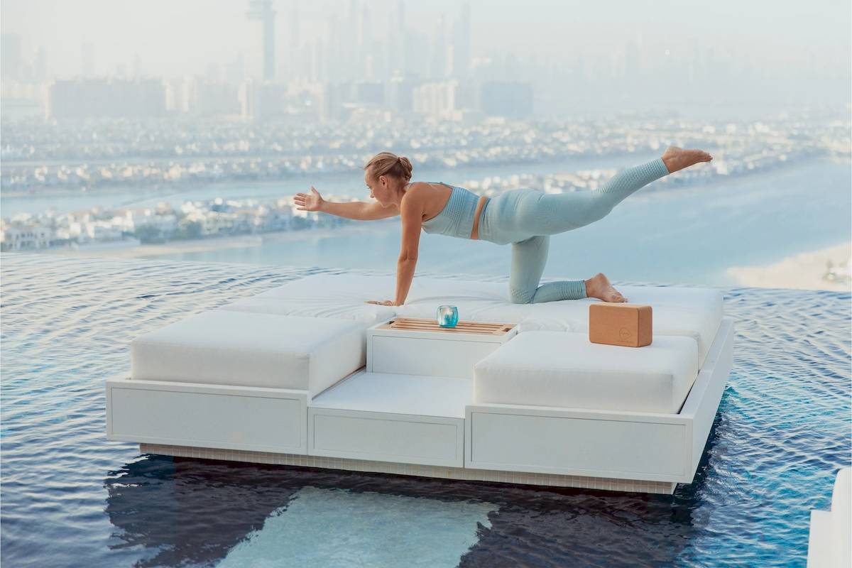 Eine Frau praktiziert Yoga auf einer schwimmenden Couch im Atlantis The Royal.