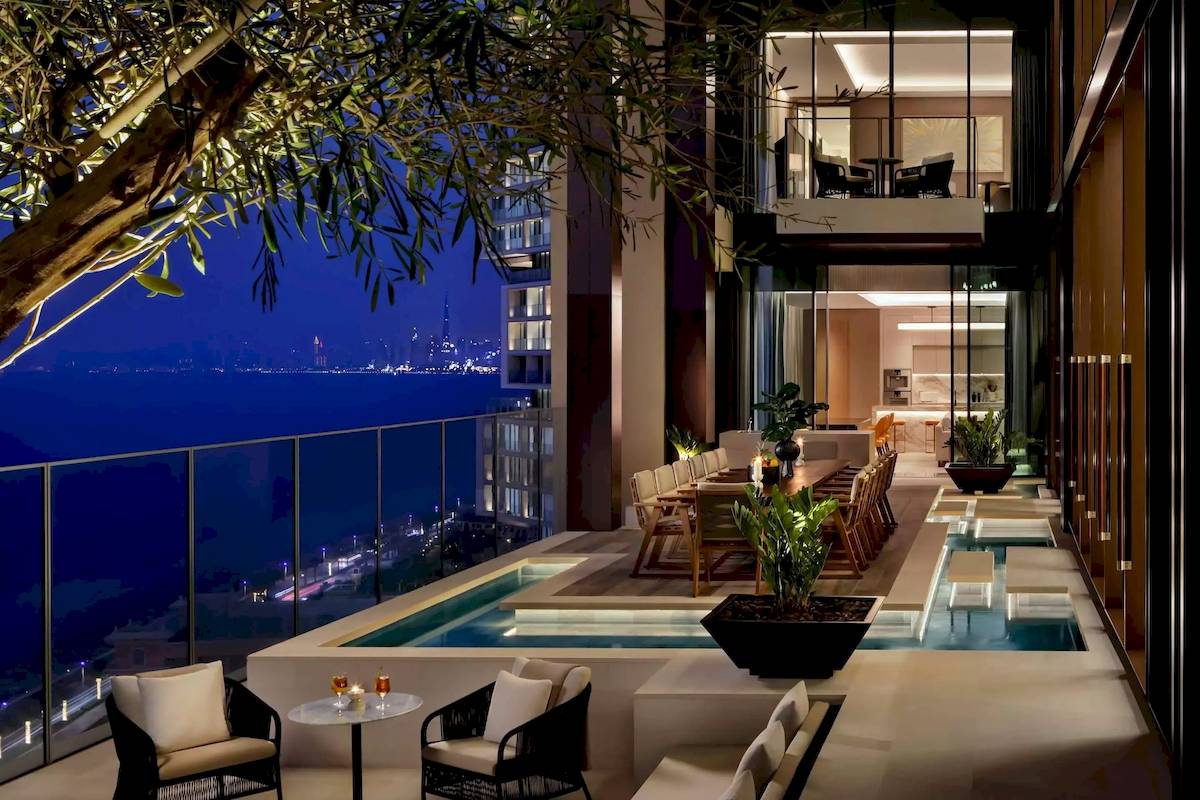 Pool-Terrasse des Atlantis The Royal Hotels mit Blick auf die Stadt bei Nacht.