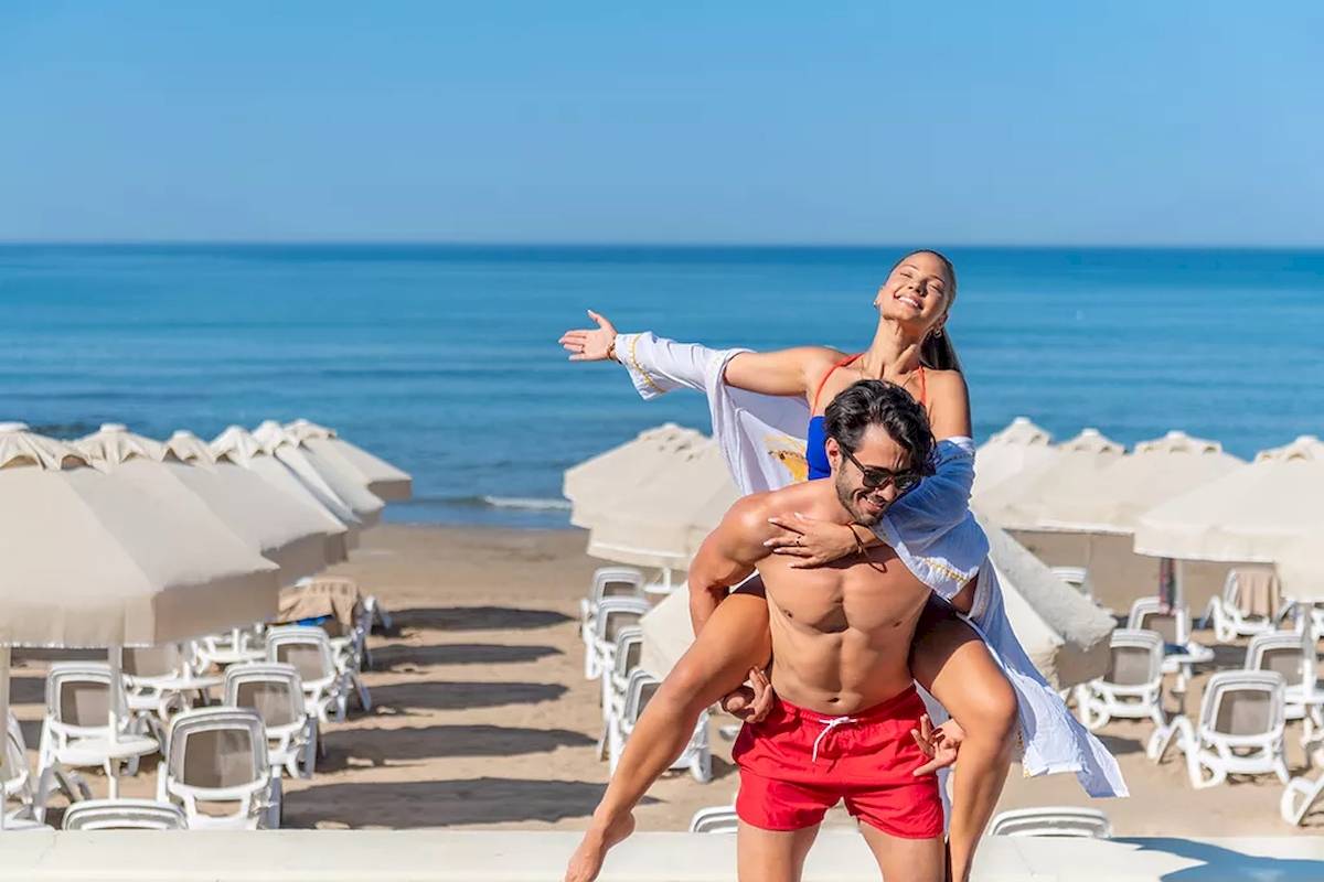 Ein Paar genießt die Aussicht auf das Meer am Strand des Melas Resorts im Sommer.