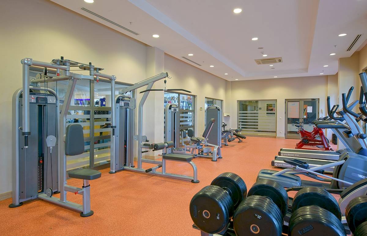 Fitnesscenter im Novum Garden Side Hotel mit verschiedenen Geräten und Hanteln.