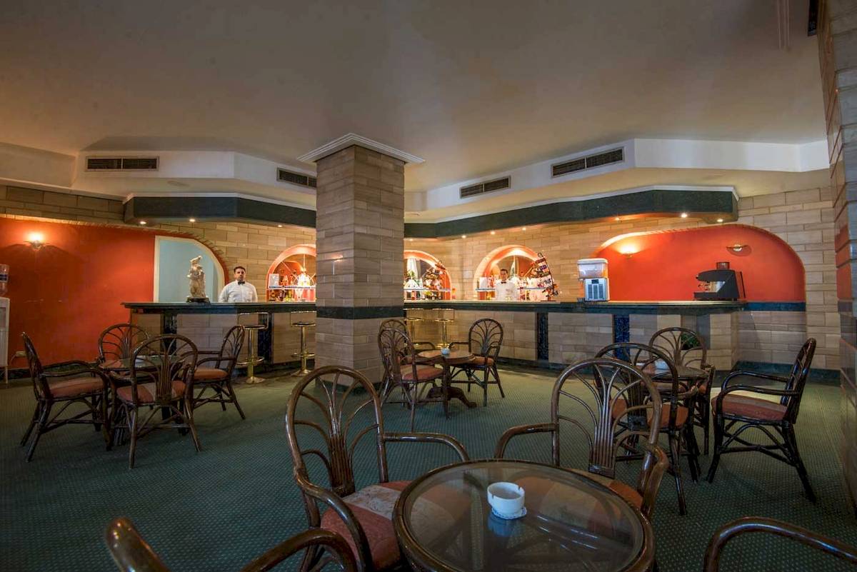 Hotelbar im Shams Safaga Resort mit Barkeepern und runden Tischen.