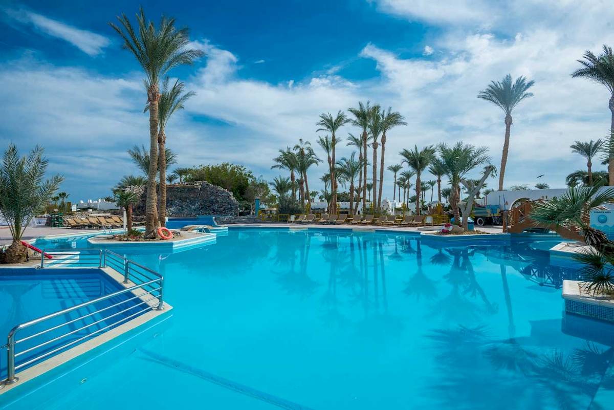 Ein großer Swimmingpool im Shams Safaga Resort mit blauem Wasser und Palmen.