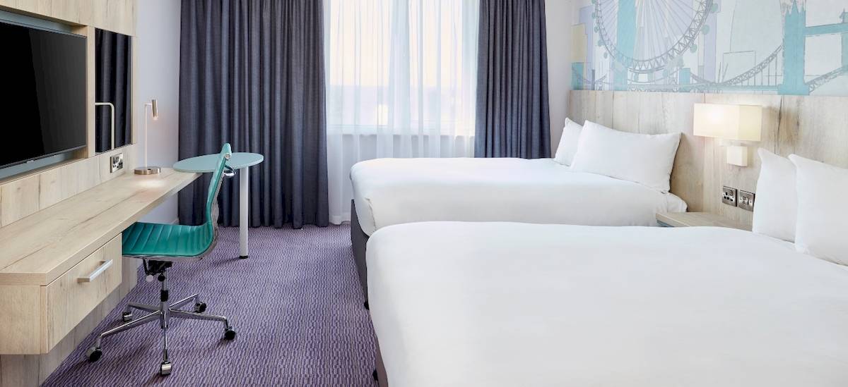 Doppelzimmer im Leonardo Hotel London Croydon mit zwei Betten, Schreibtisch und Fernseher.