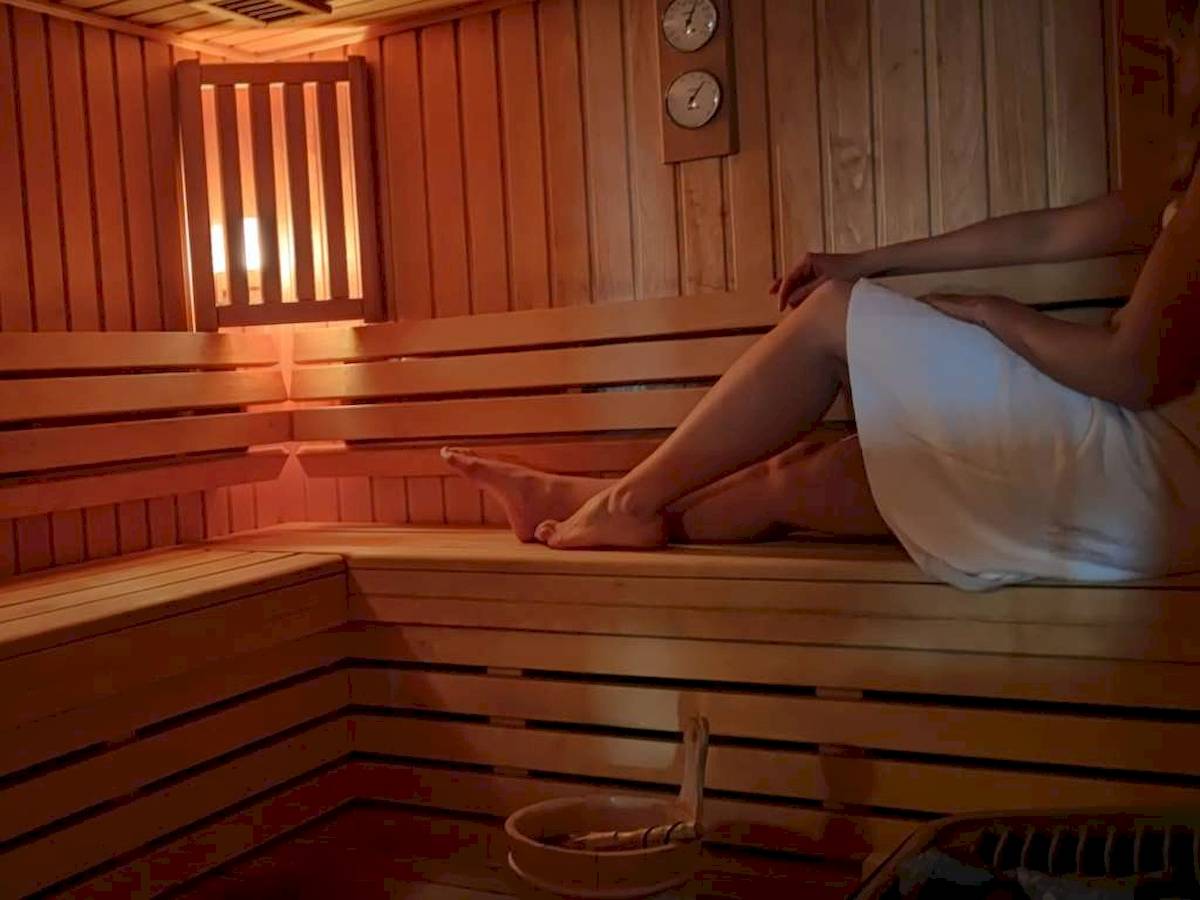 Eine Person sitzt in einer Holzsauna im Novotel Paris Tour Eiffel Hotel.