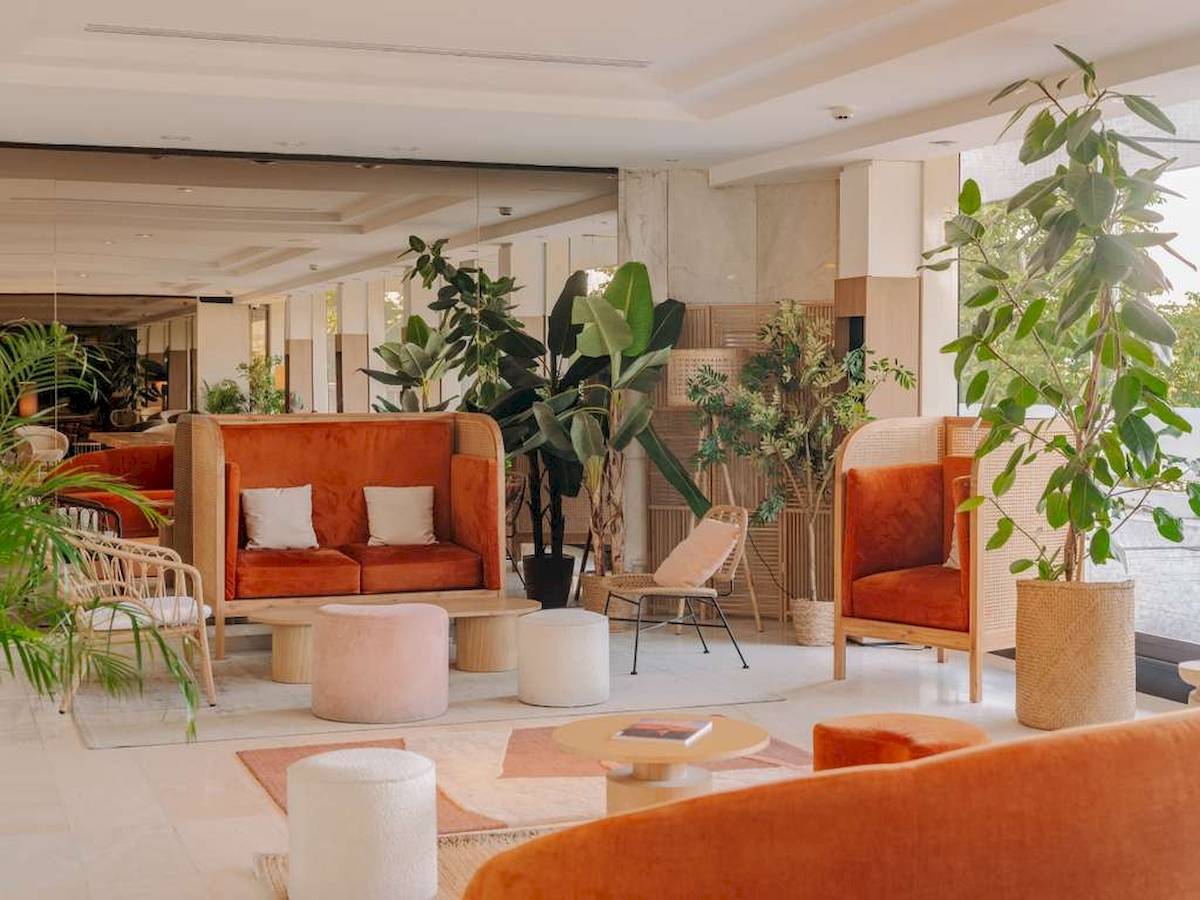 Hotellobby mit orangefarbenen Möbeln und Pflanzen, Novotel Paris Tour Eiffel
