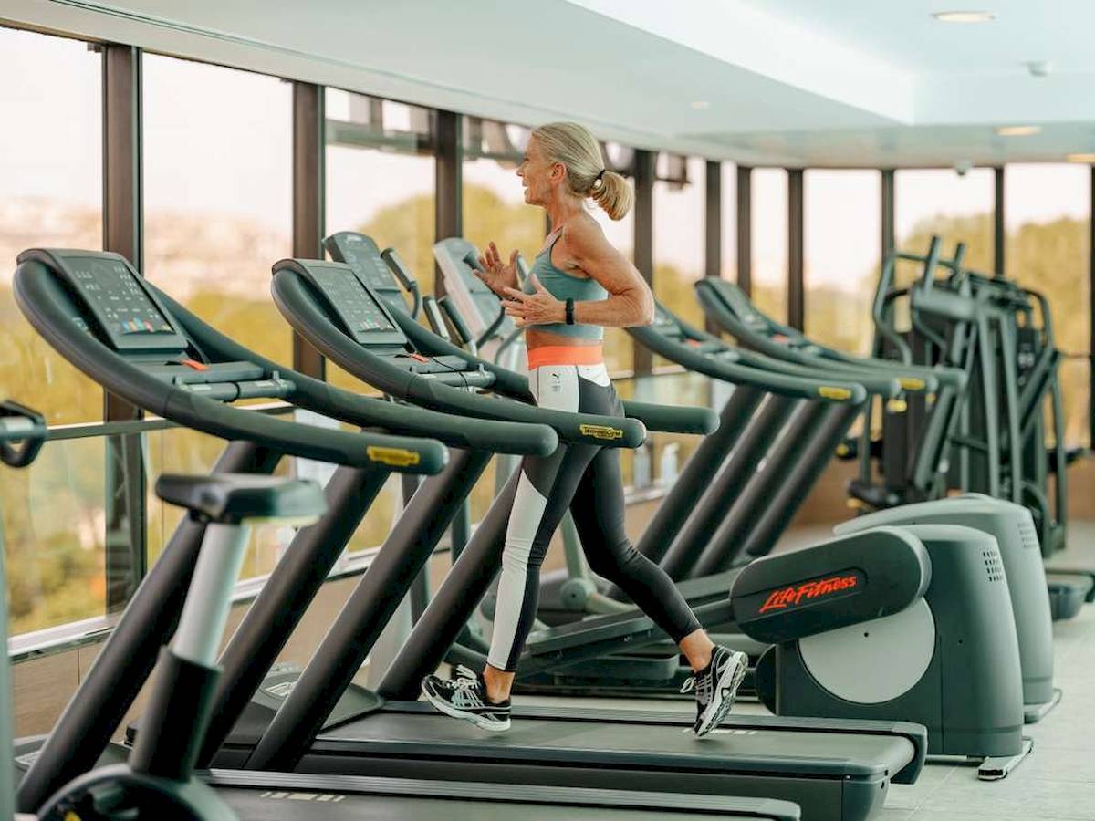 Eine ältere Frau läuft auf einem Laufband im Fitnessstudio des Novotel Paris Tour Eiffel.