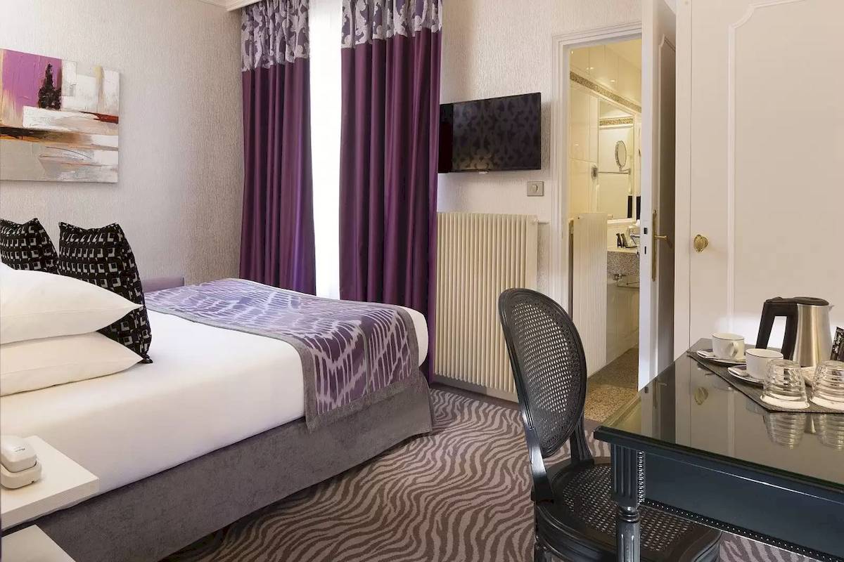 Hotelzimmer im Victor Hugo Paris Kléber mit Bett, Schreibtisch und Fernseher