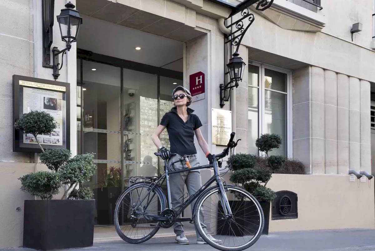 Frau mit Fahrrad vor dem Hotel Victor Hugo Paris Kléber