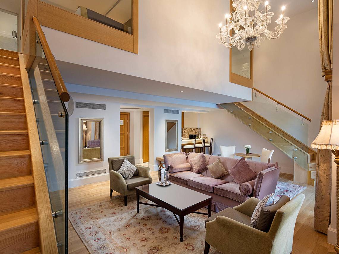 Ein modernes Hotel-Lobby-Design mit Sofa, Tisch, Kristallleuchter und Glastreppe.