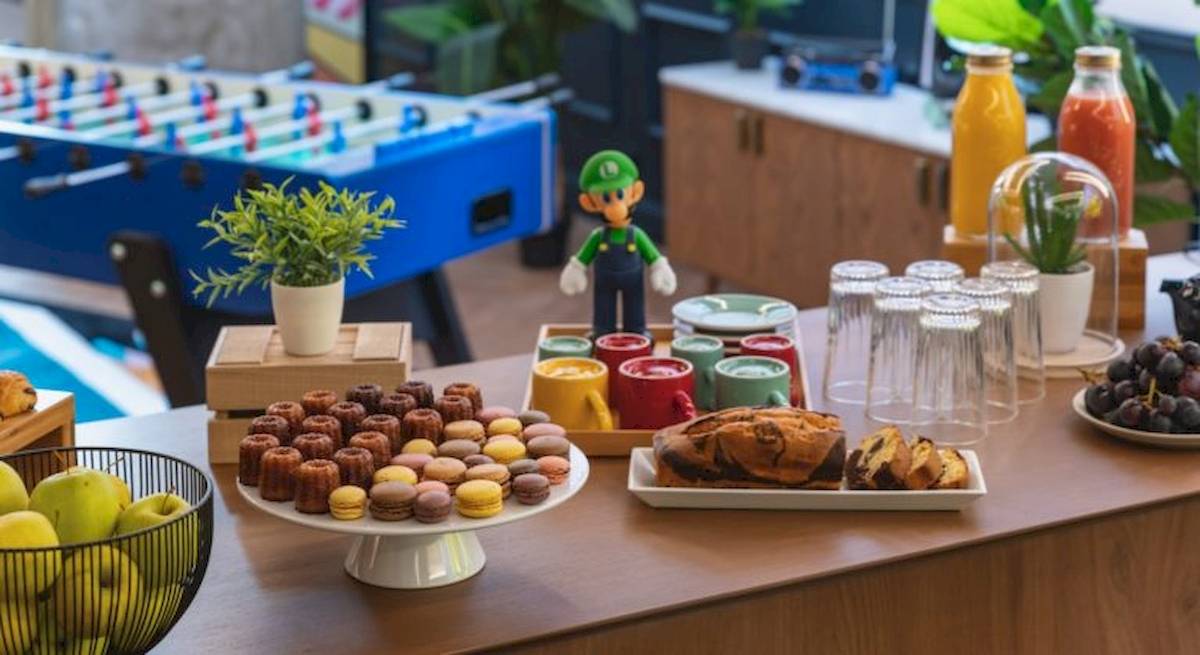 Frühstücksbuffet im ReMIX Hotel mit verschiedenen Desserts, Obst, Getränken und einem Mario-Figuren.