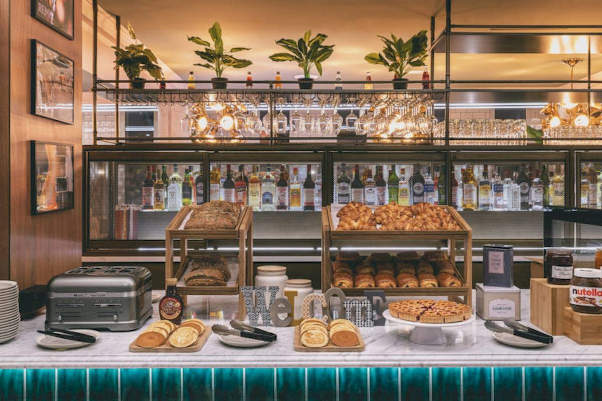 Frühstücksbuffet im ReMIX Hotel mit Croissants, Brot und Gebäck auf einer Theke.