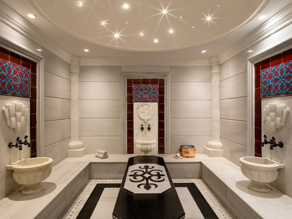 Innenansicht des Spa-Bereichs im Titanic Mardan Palace mit weißen Wänden, schwarzen und weißen Bodenfliesen und dekorativen Elementen.