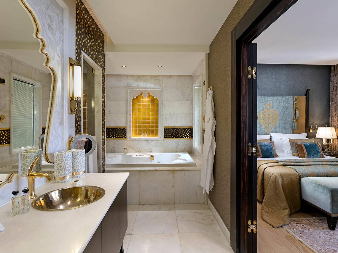 Ein Hotelzimmer mit einem Badezimmer, das eine Badewanne und einen Spiegel zeigt.