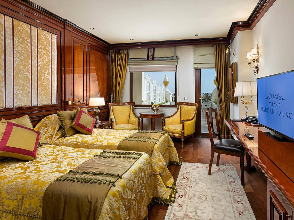 Doppelbett-Zimmer im Titanic Mardan Palace mit luxuriösem Interieur und Blick auf die Stadt.