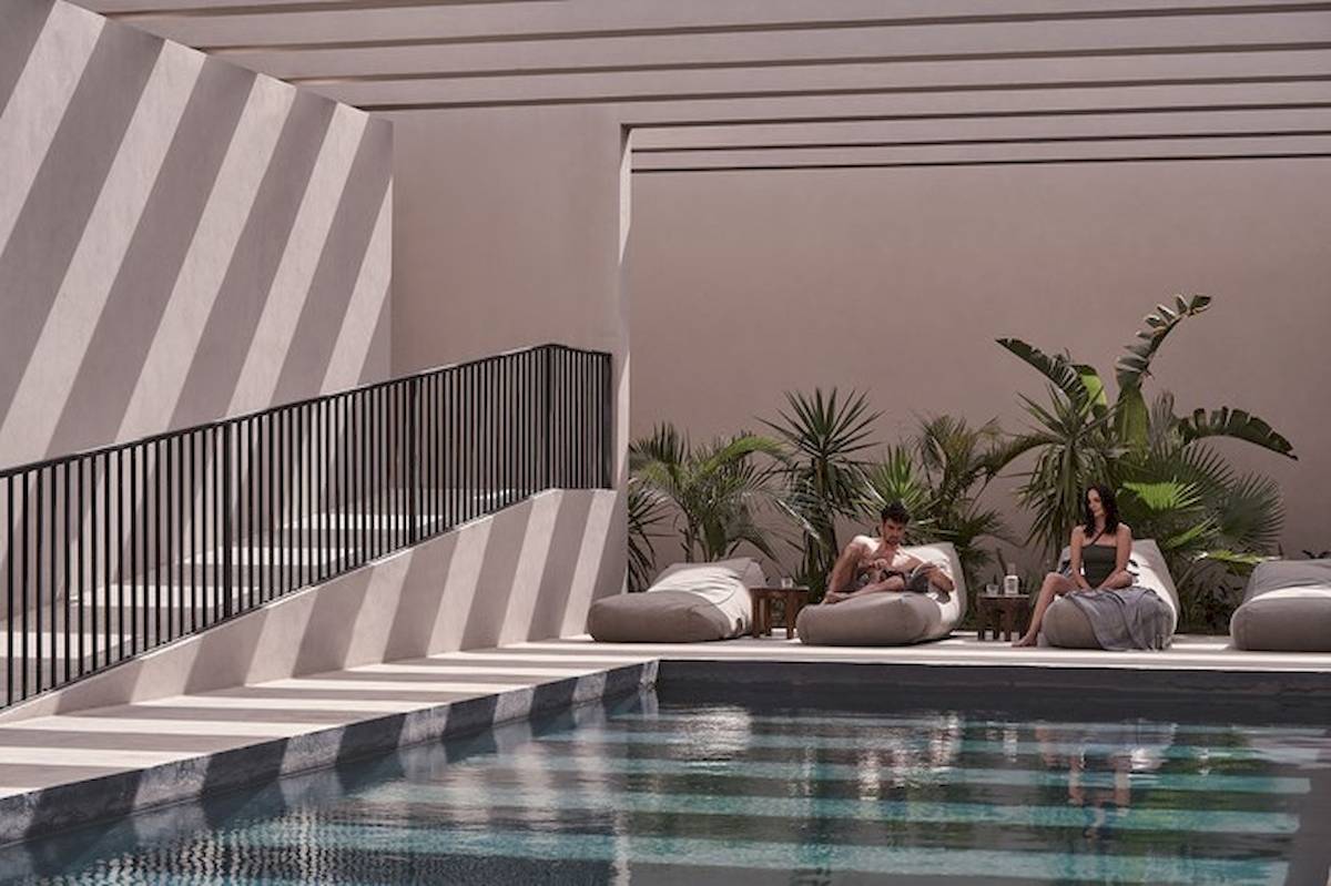 Loungebereich am Pool im Casa Cook El Gouna Hotel mit zwei Personen, die auf Sesseln sitzen.