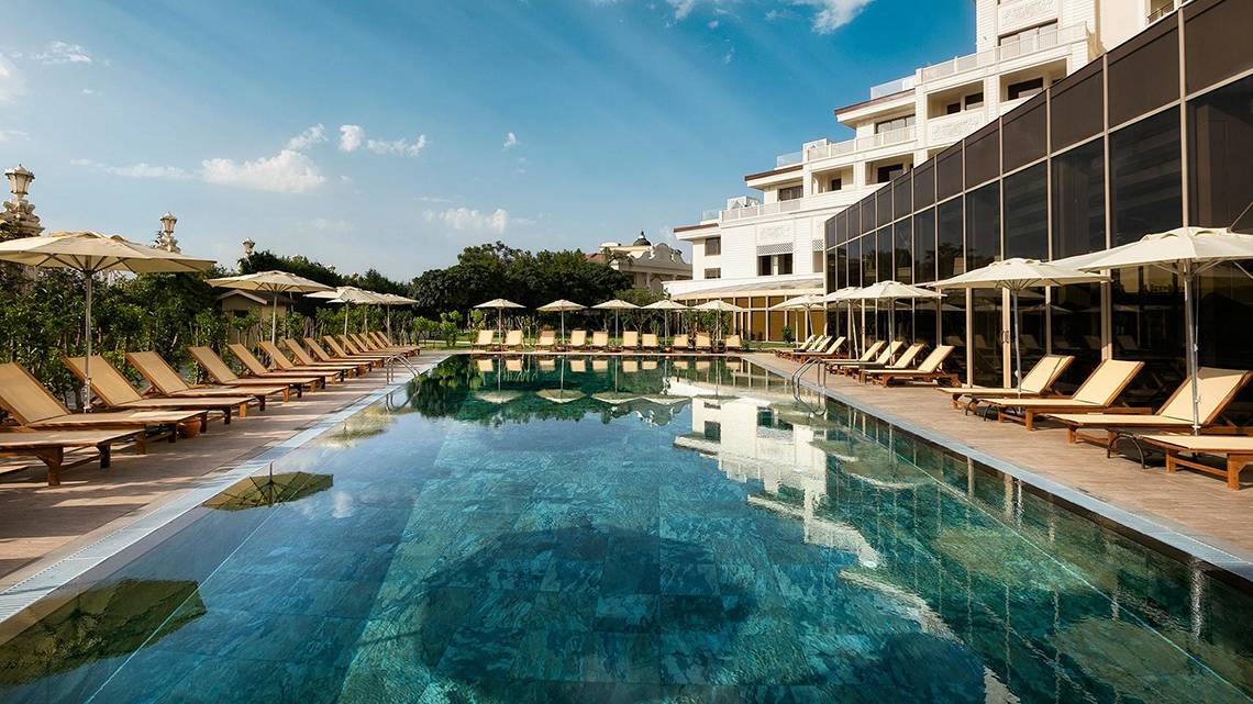 Außenpool des Titanic Mardan Palace Hotels mit Loungeliegen und Sonnenschirmen