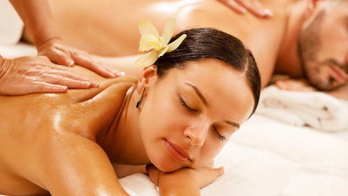 Massage im Sunrise Queen Luxury Hotel mit einer Frau, die auf einem weißen Handtuch liegt.