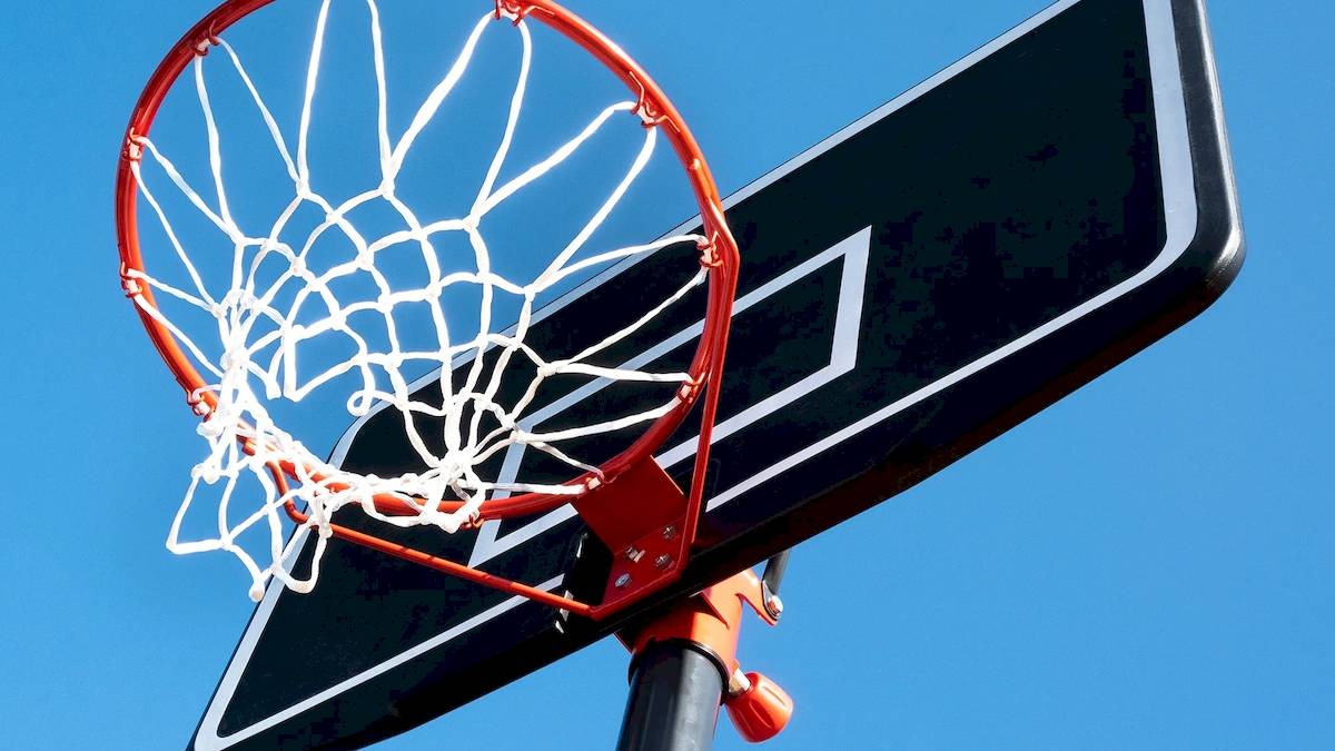 Basketballkorb mit Netz am Korbbrett, das an einem Pfosten befestigt ist.