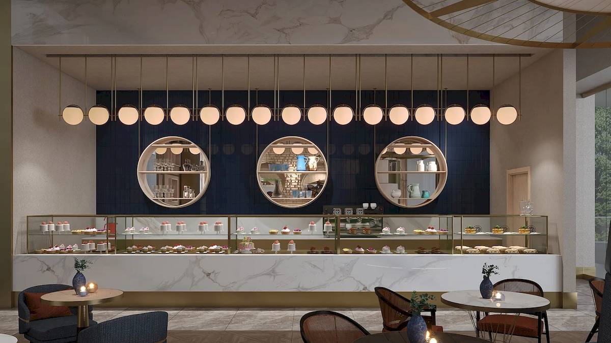 Innenansicht des Cafes des Sunrise Queen Luxury Hotel mit Marmortheke und beleuchteten Kuchen