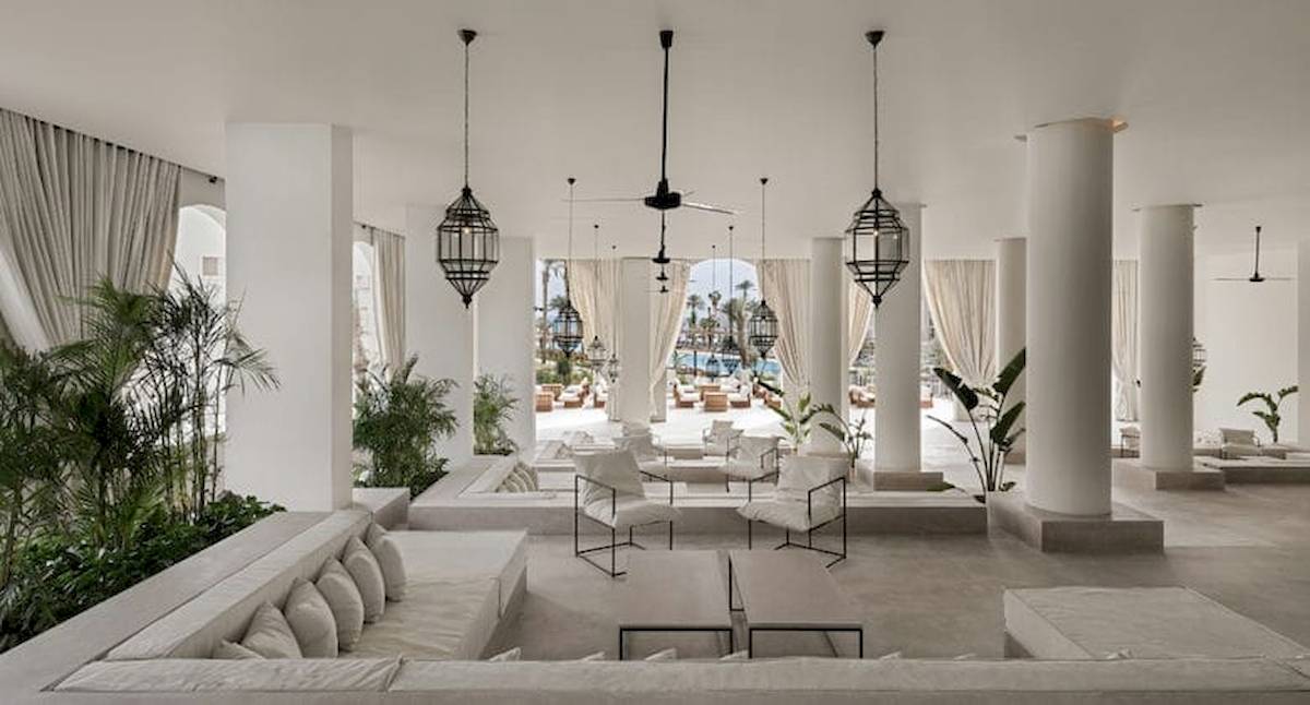 Lobby des Serry Beach Resorts mit weißen Möbeln, Säulen und Pflanzen.