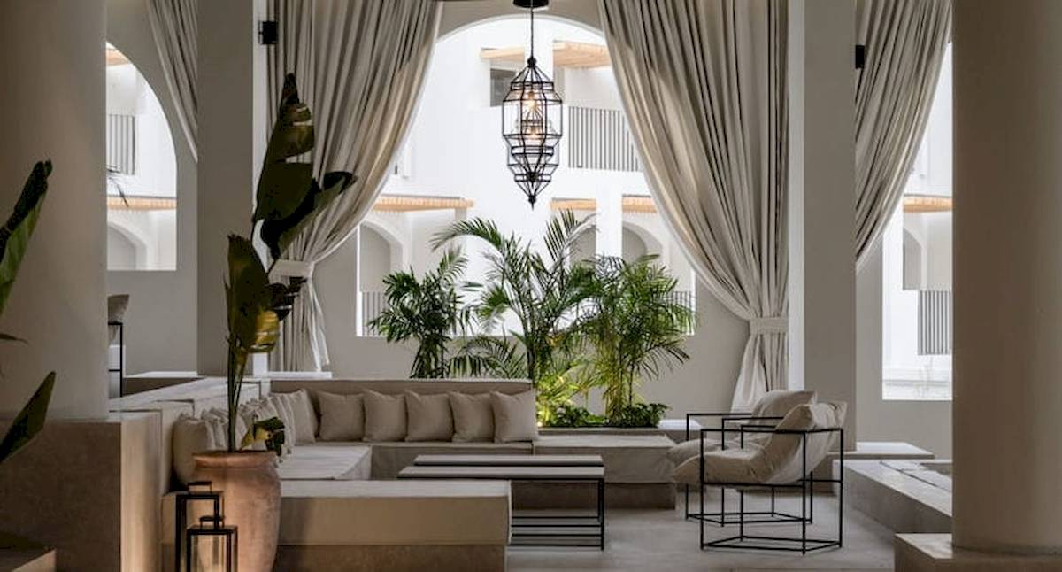 Serry Beach Resort Lobby mit weißem Möbeln, Kissen, Lampen und Pflanzen.