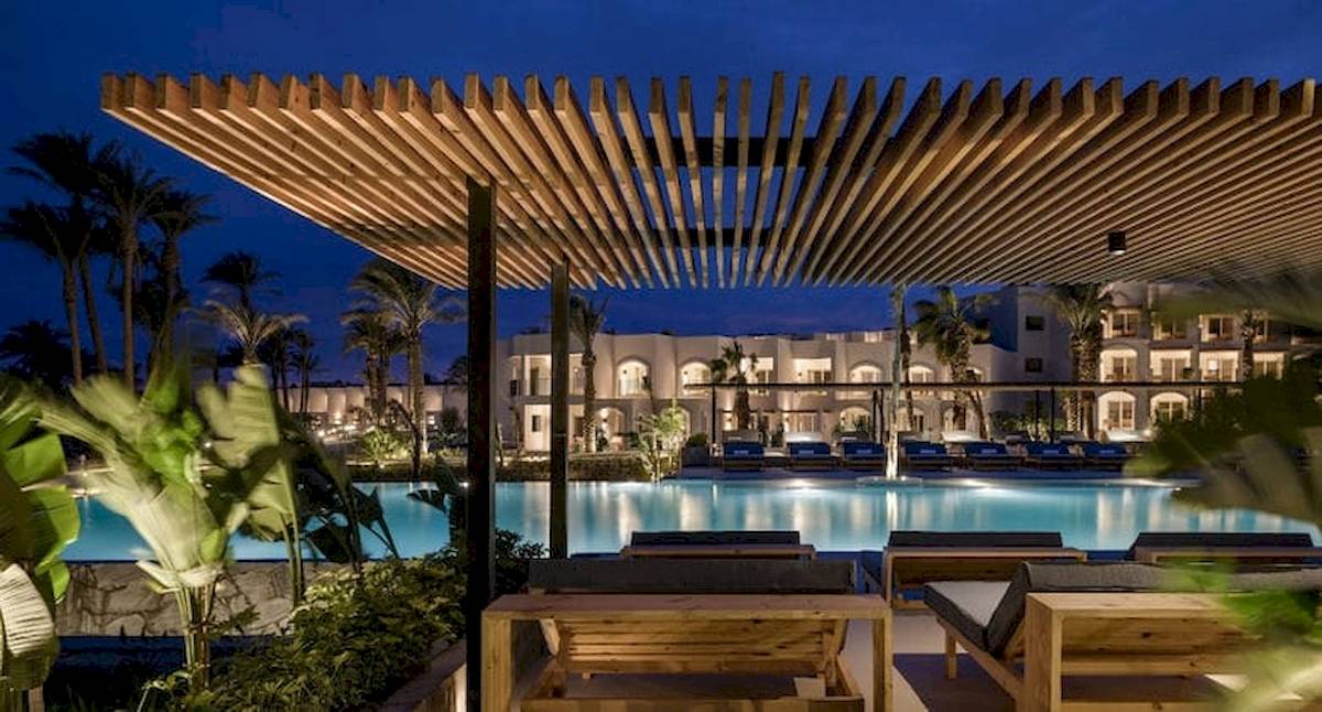 Außenbereich des Serry Beach Resorts bei Nacht mit Holzliegen und Dachterrasse