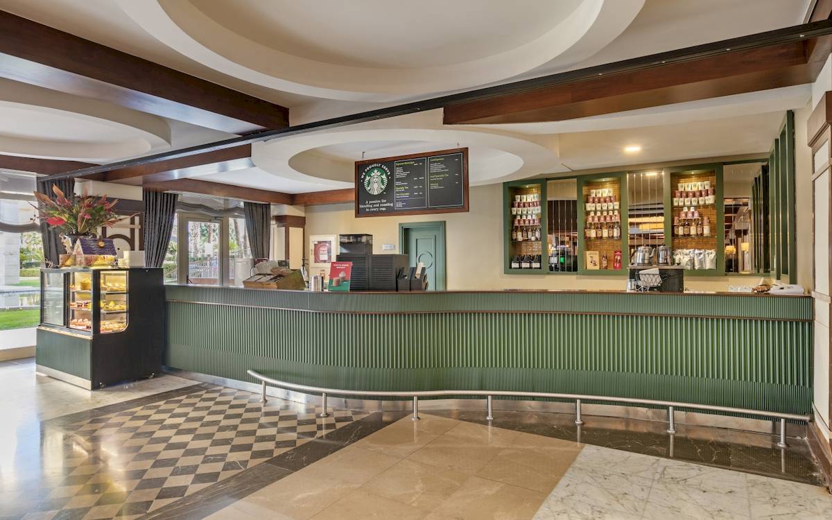 Rezeption im Dobedan Exclusive Hotel & Spa Belek mit grüner Theke und Starbucks-Schild