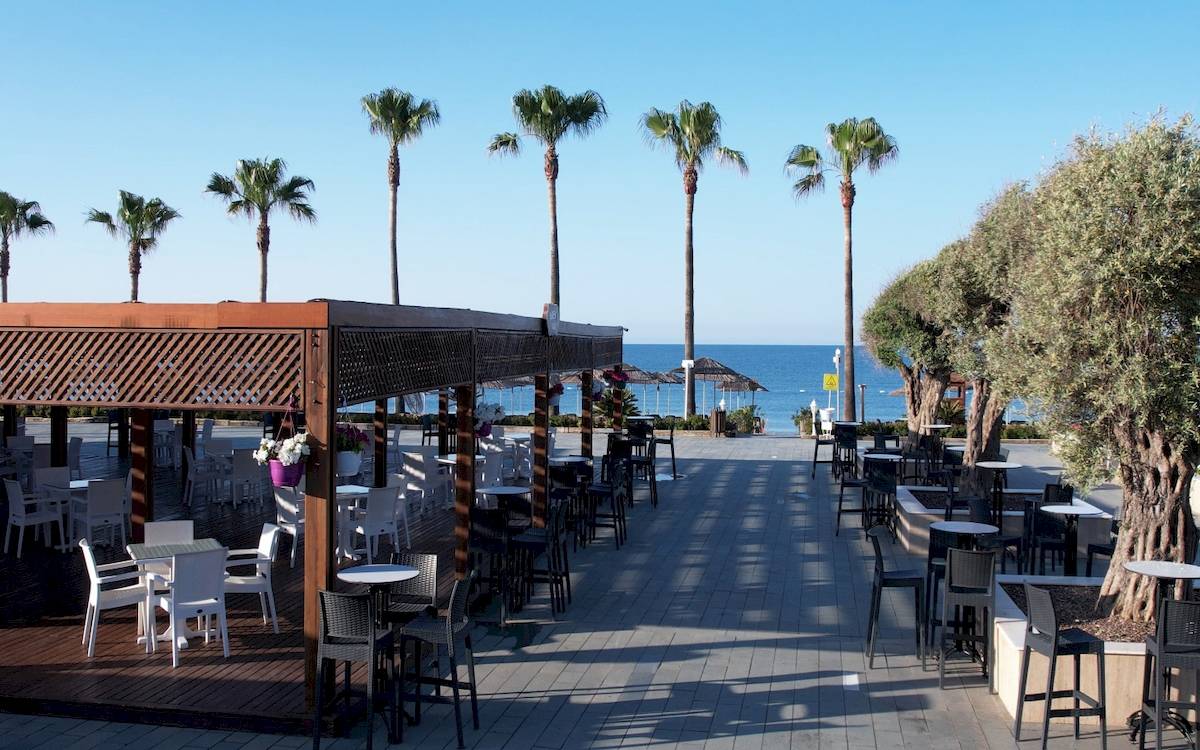 Terrasse des Dobedan Exclusive Hotel & Spa Belek mit weißen Tischen und Stühlen, Palmen und Meerblick