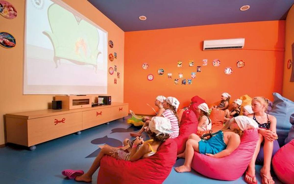 Kinder sitzen in roten und pinken Sitzsäcken im Kinoraum des Limak Atlantis Deluxe Hotel & Resort