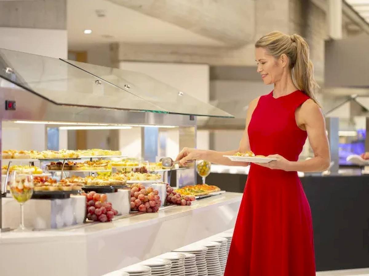Frau im roten Kleid bedient Buffet im Hipotels Mediterraneo