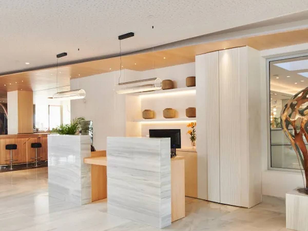 Reception im Hipotels Mediterraneo mit weißen Marmor und moderner Einrichtung.