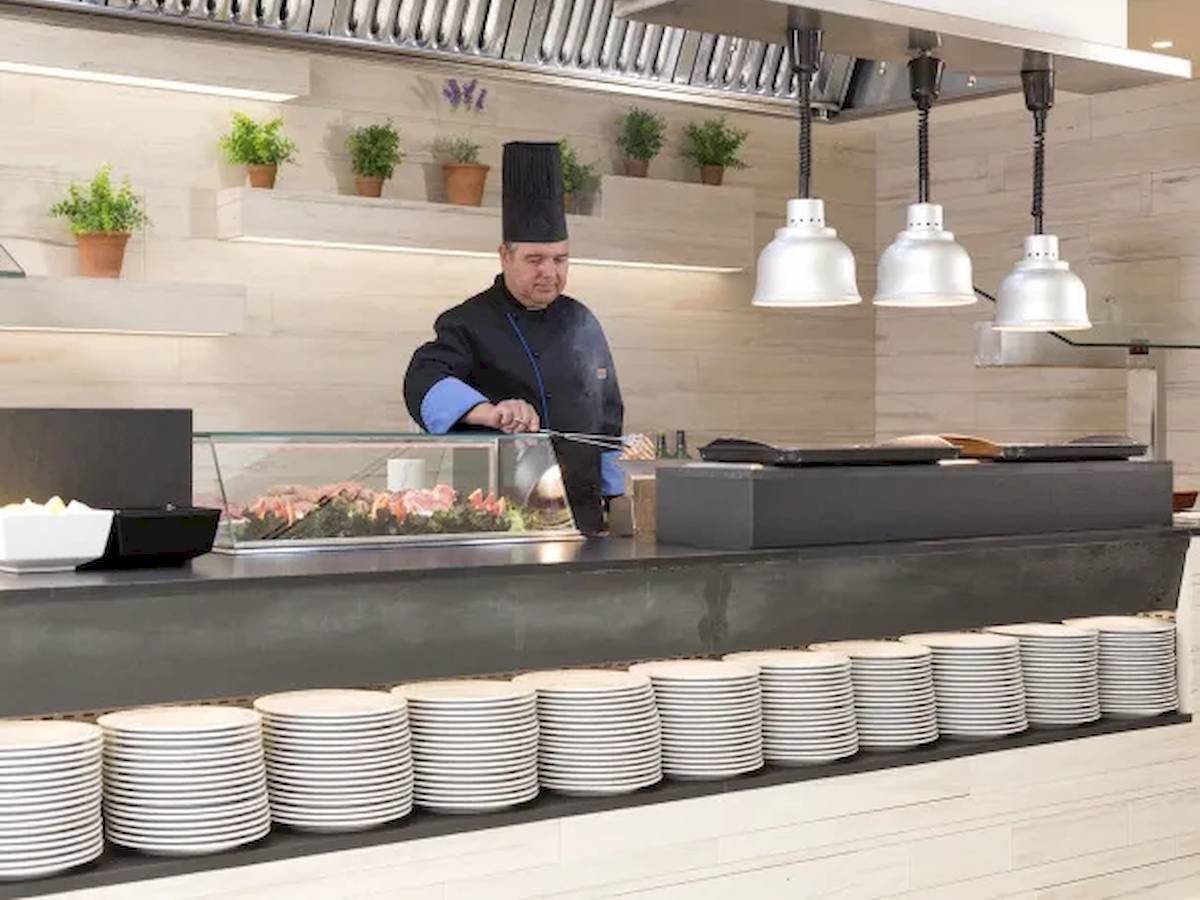 Koch im Restaurant des Hipotels Mediterraneo, der eine Speise zubereitet.