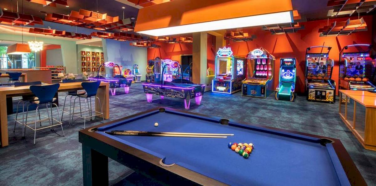Spielbereich im Lopesan Costa Bavaro Resort mit Billardtisch, Spielautomaten und Sitzgelegenheiten.