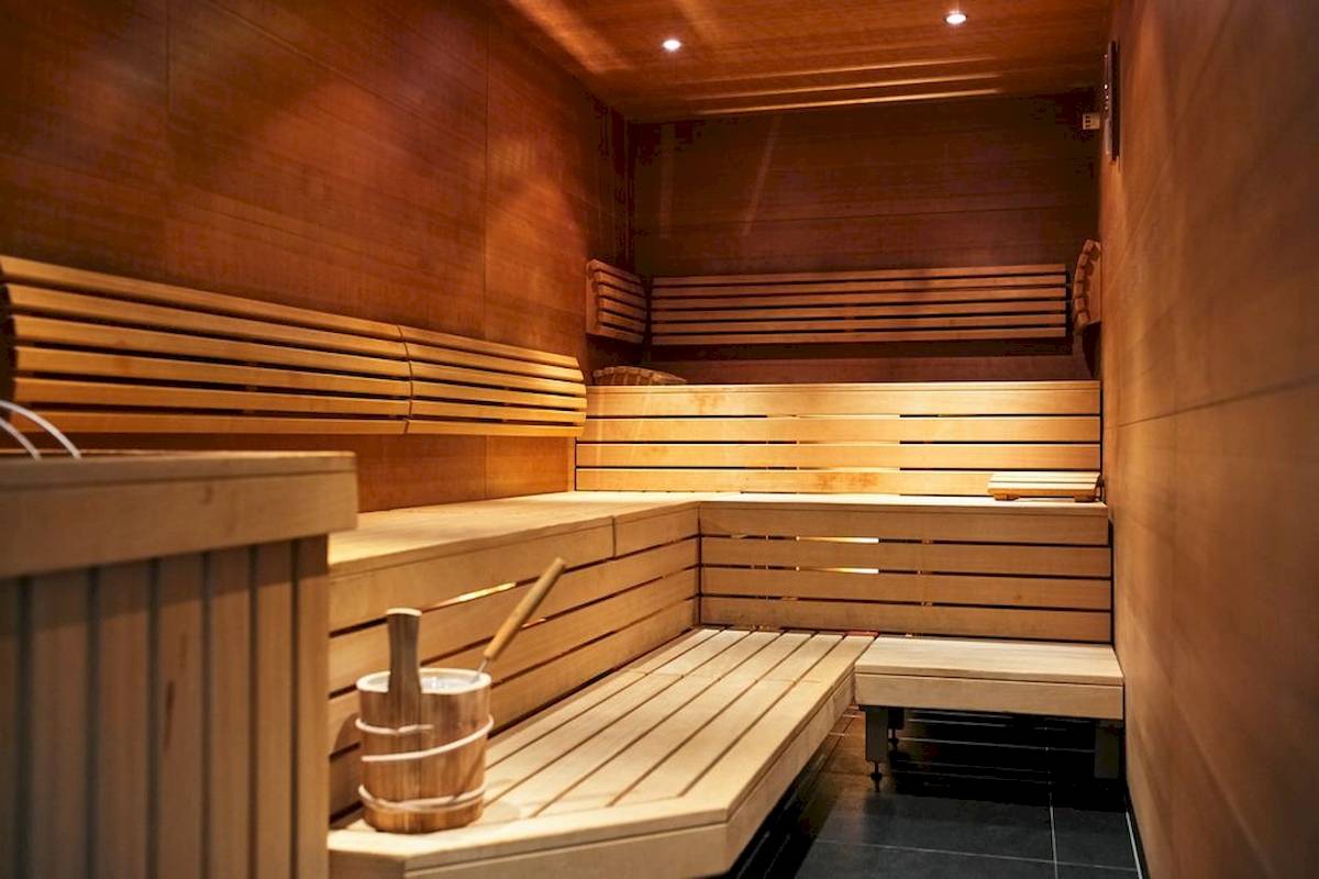 Innenansicht der Sauna im MAXX by Steigenberger Hotel in Wien mit Holzbänken und Eimern.