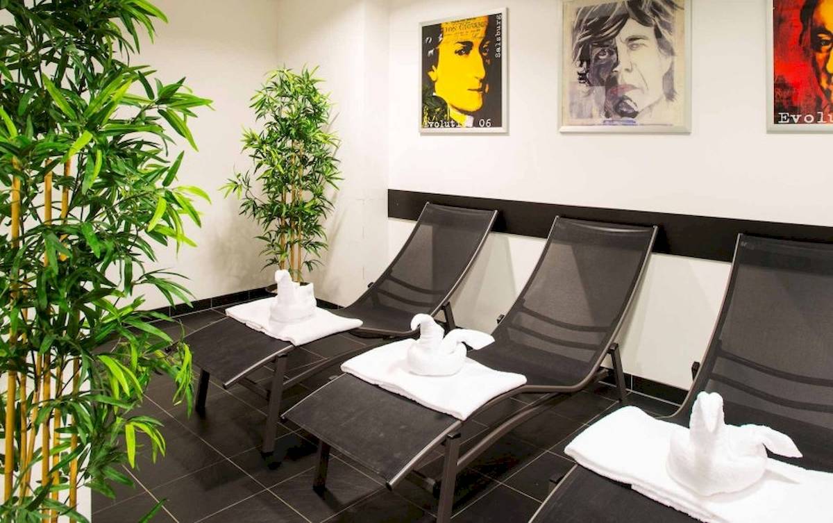 Relaxationsbereich im Best Western Plus Amedia Wien mit vier schwarzen Liegen und weißen Handtüchern.