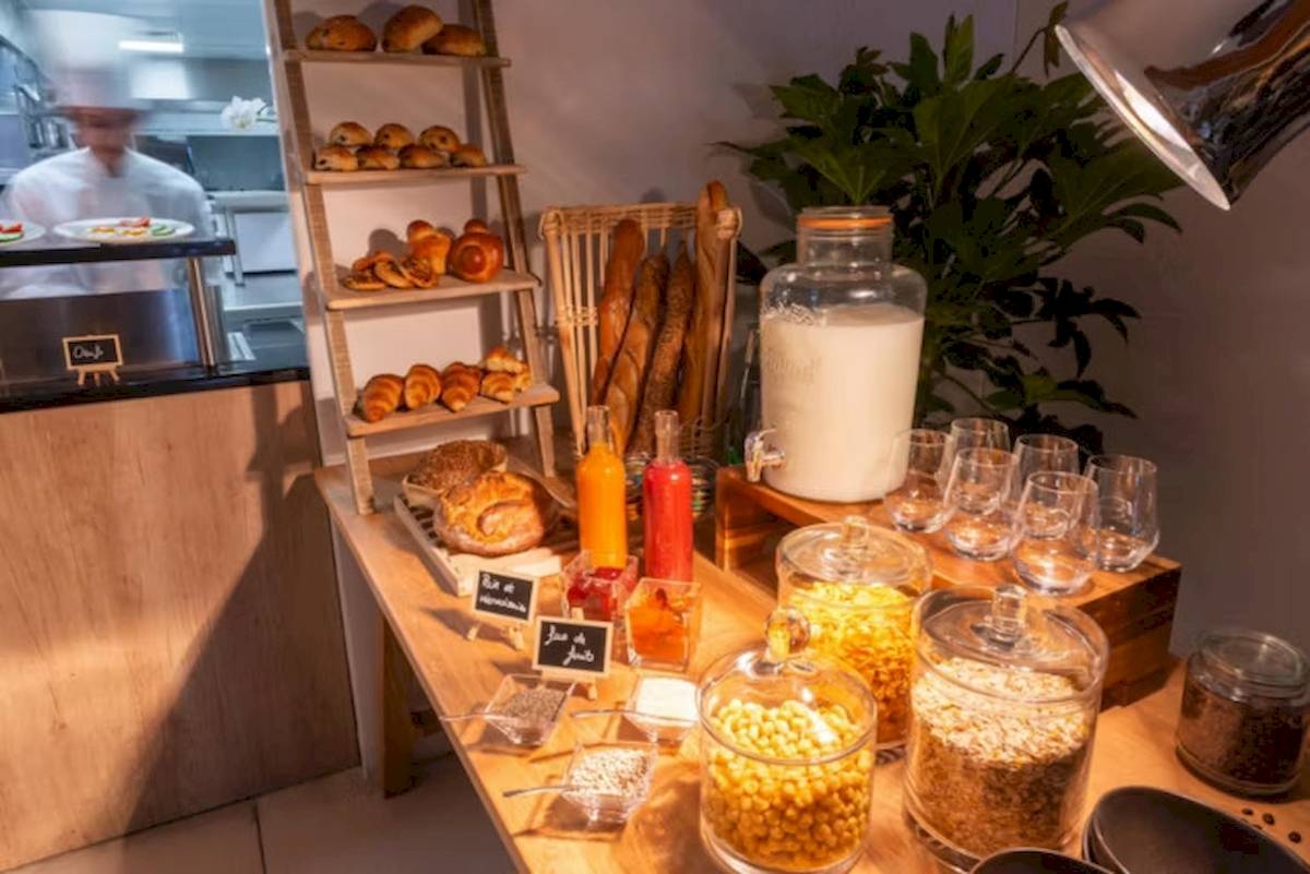 Frühstücksbuffet im Hotel Crowne Plaza Paris République mit Brot, Gebäck, Getränken und Cerealien.
