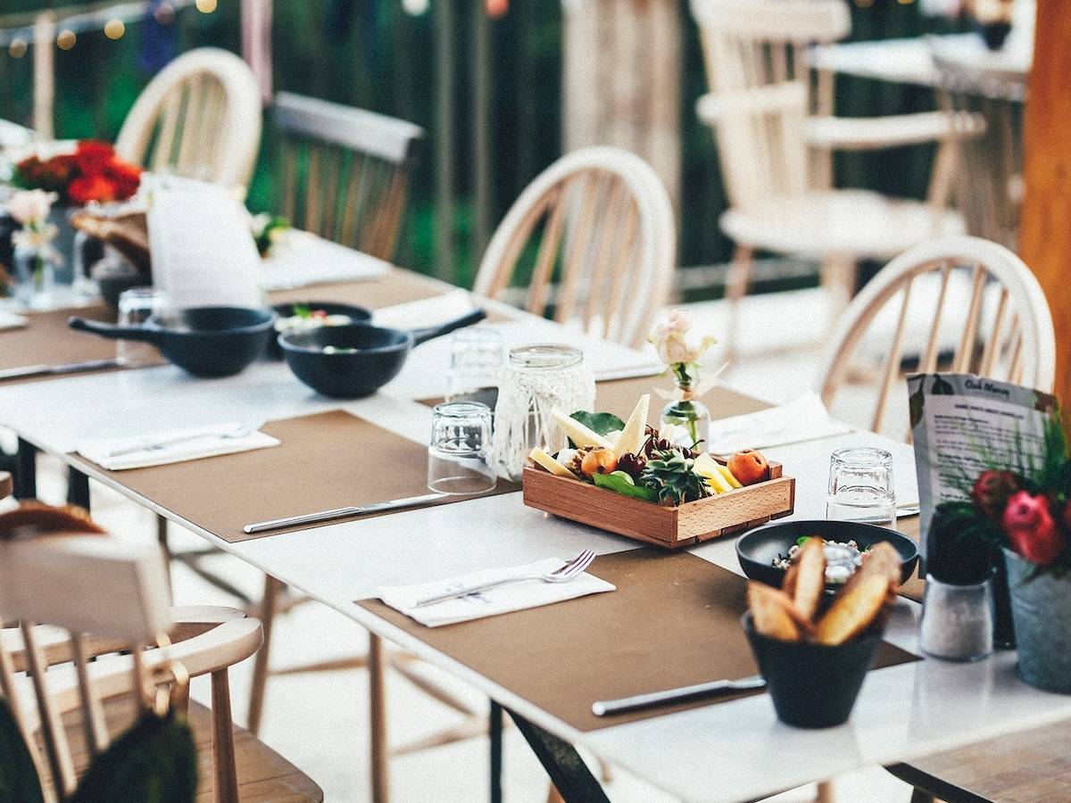 Ein gedeckter Tisch im Garten des Club Marvy Hotels mit verschiedenen Gerichten und Dekorationen.
