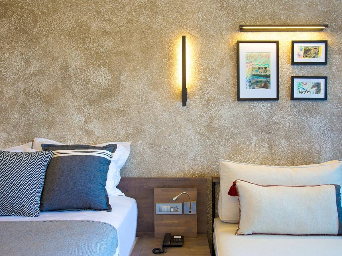 Schlafzimmer im Club Marvy Hotel mit zwei Betten, Nachttischen und Dekorahmen an der Wand.