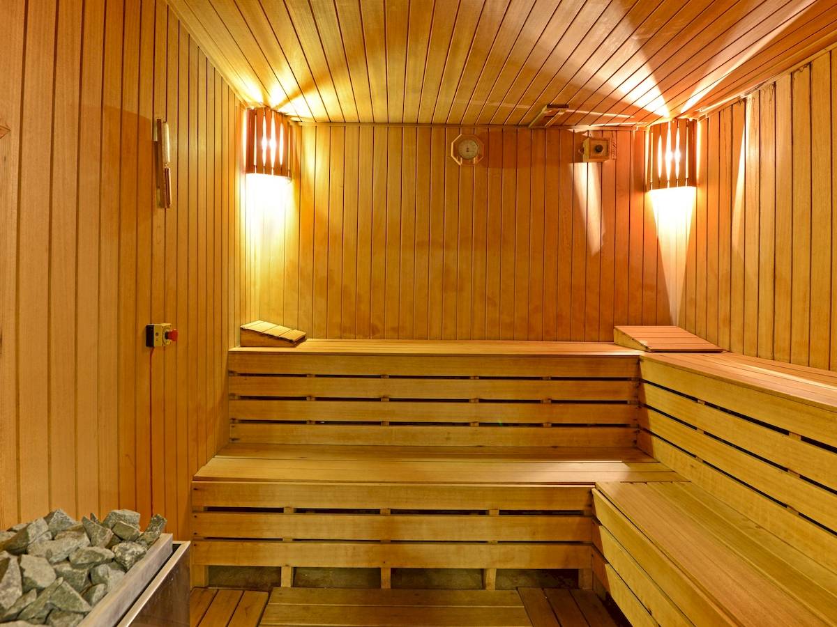 Innenansicht eines Saunaraums im Yigitalp Hotel mit Holzwänden und Bänken, beleuchtet.