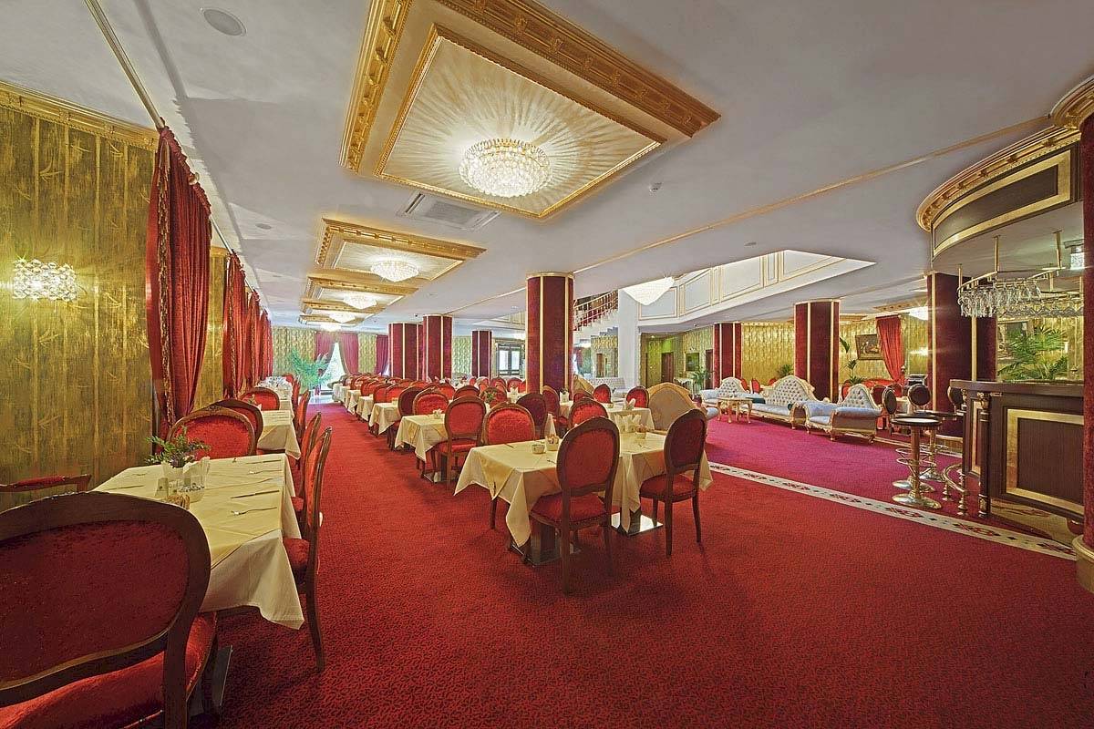 Innenbereich des Antea Palace Hotel & Spa Restaurants mit roten Teppichen und goldenen Wandverzierungen.