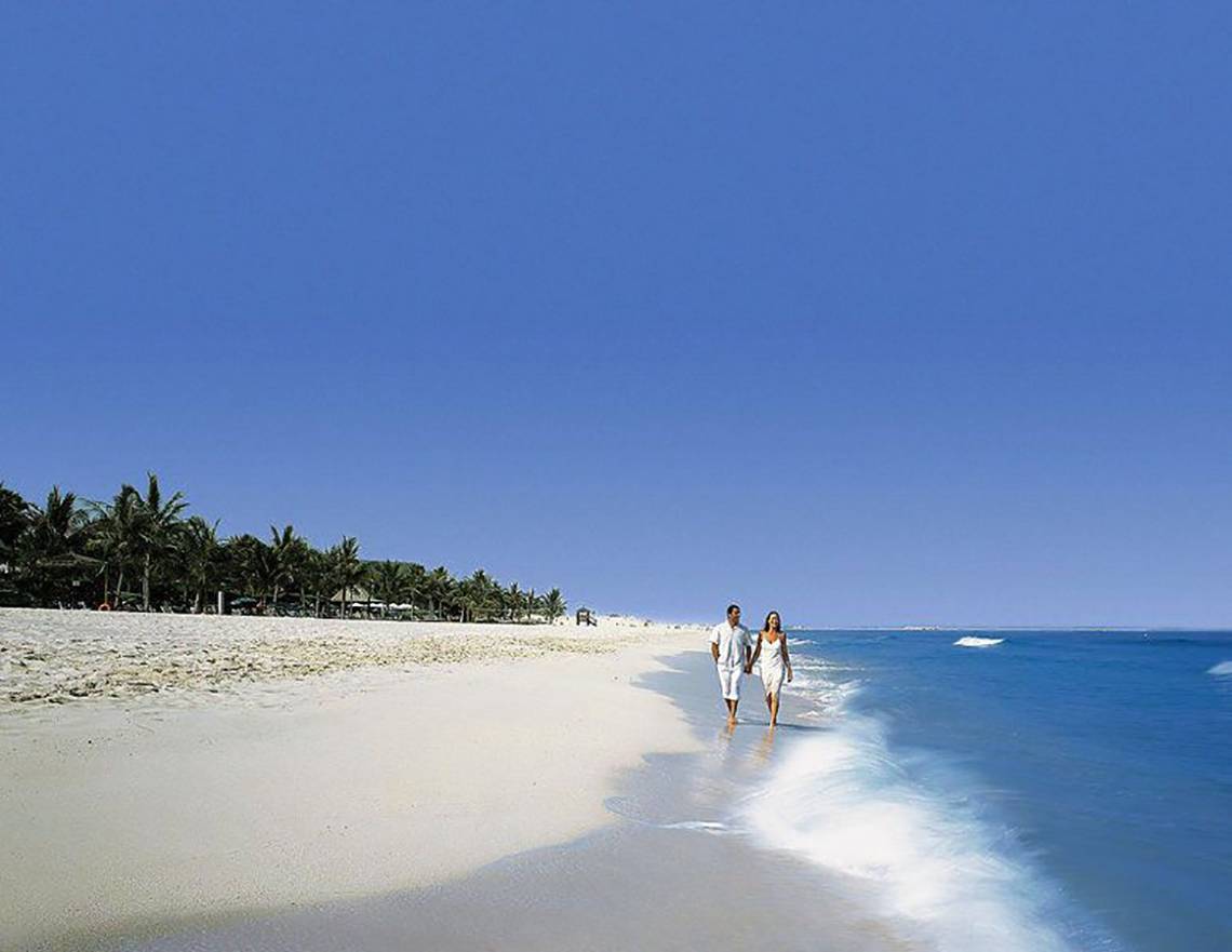 Paar am Strand vor dem JA Beach Hotel