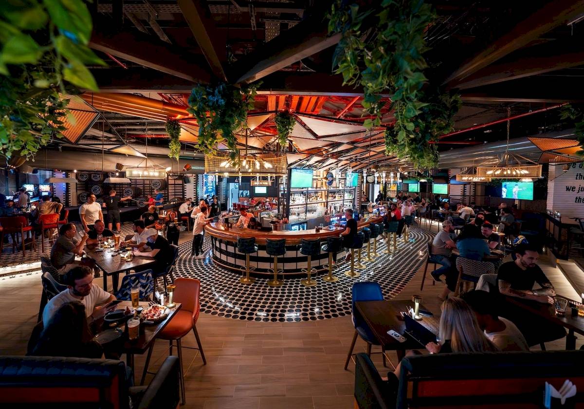 Innenbereich der Bar im FIVE LUXE JBR Hotel mit Gästen, die an Tischen sitzen und trinken.