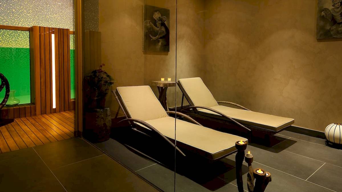 Relaxationsraum im Doubletree by Hilton Istanbul Moda mit zwei Liegen, einem Tisch und weichen Kerzen auf den Tisch.