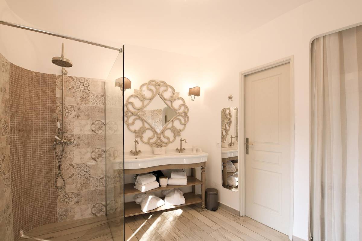 Badezimmer im L'Hostellerie du Moulin mit begehbarer Dusche, zwei Waschbecken und Spiegel.