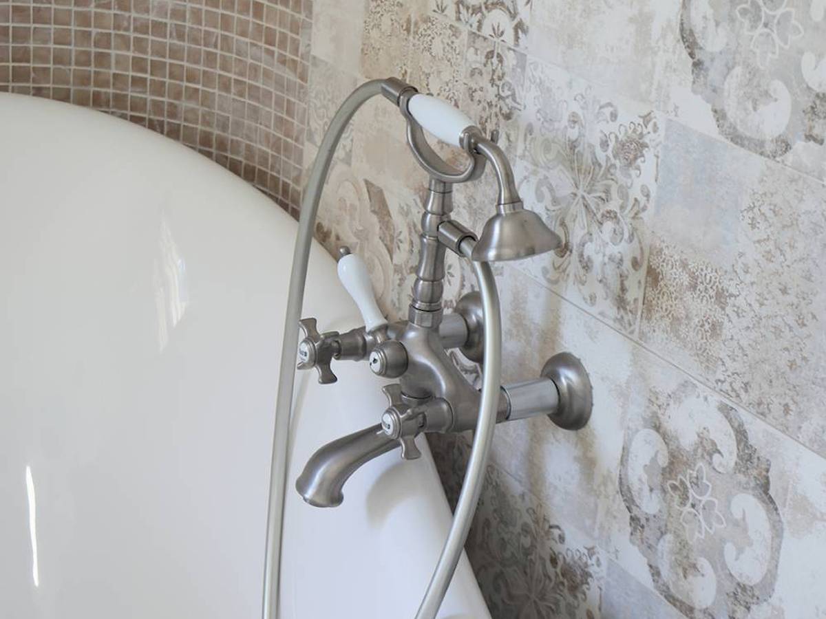 Ein Badezimmer mit einer weißen Badewanne und modernen Armaturen.
