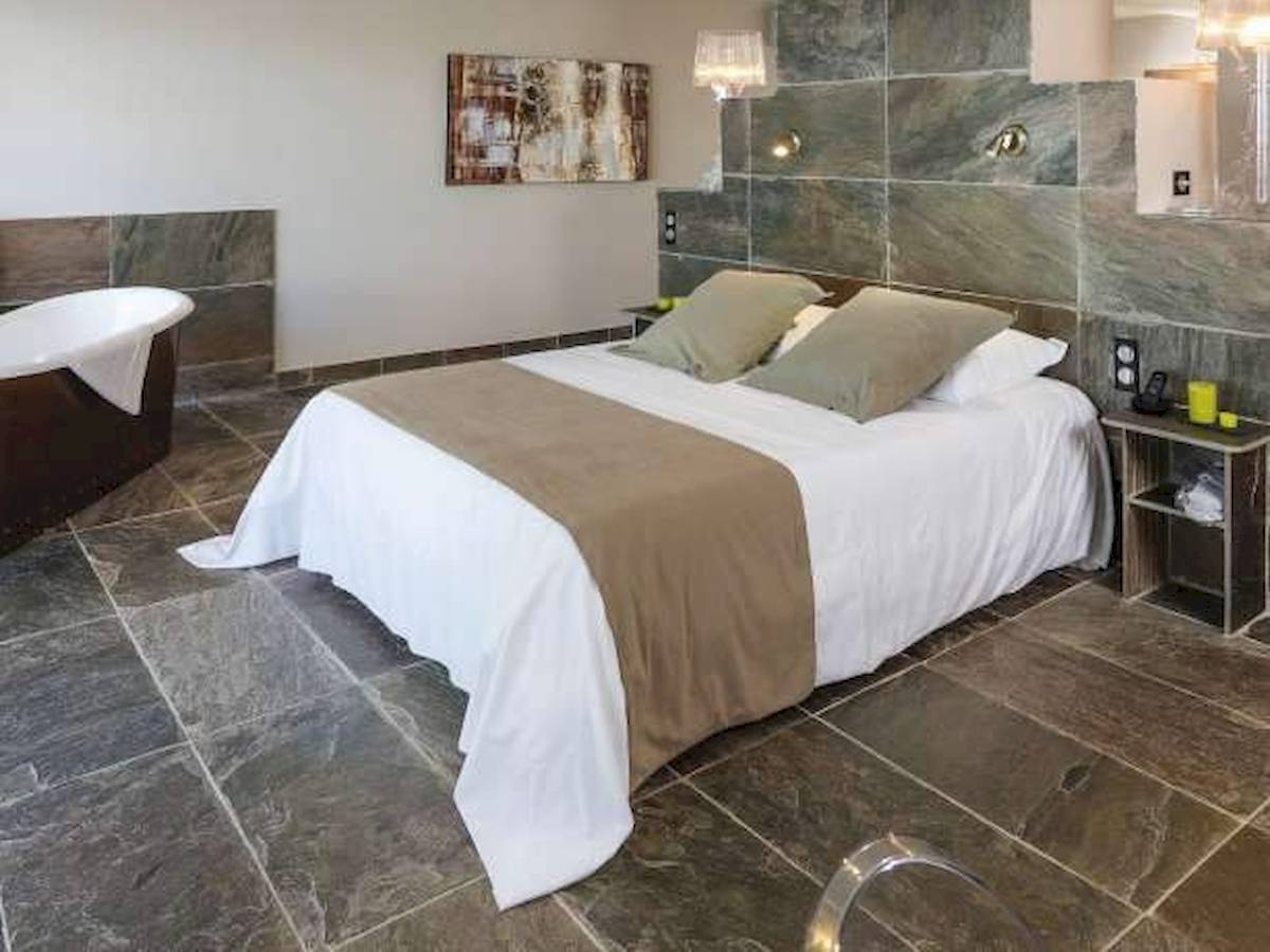 Schlafzimmer im Hotel La Lagune mit einem großen Bett und Badewanne