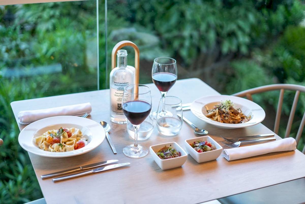 Speisetisch im ARTIEM Audax Hotel mit Gerichten, Wein und Getränken.
