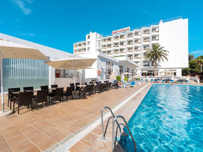 Außenbereich des Globales Lord Nelson Hotels mit Swimmingpool, Sonnenliegen und Tischen.