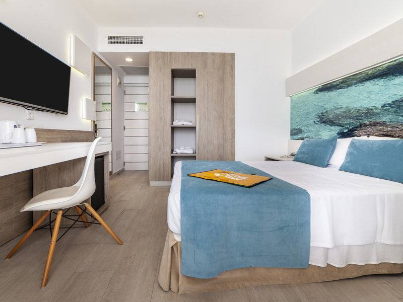 Ein modernes Hotelzimmer im Globales Lord Nelson mit einem Bett, Schreibtisch, Fernseher und einem Panoramafenster.