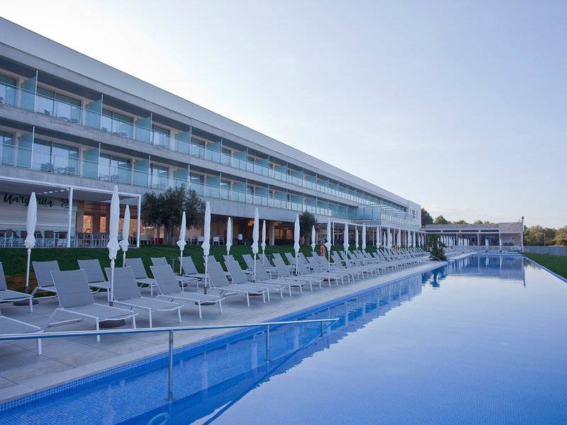 Außenbereich des Seth 55 Santo Tomás Hotels mit Swimmingpool und Liegestühlen.